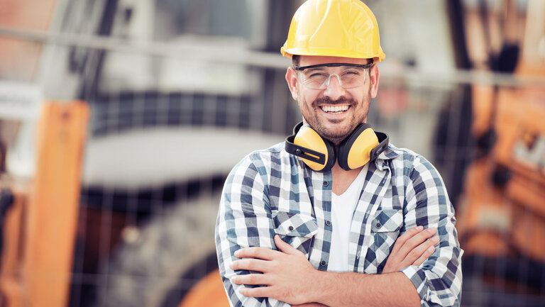 Lachender Bauarbeiter mit Helm